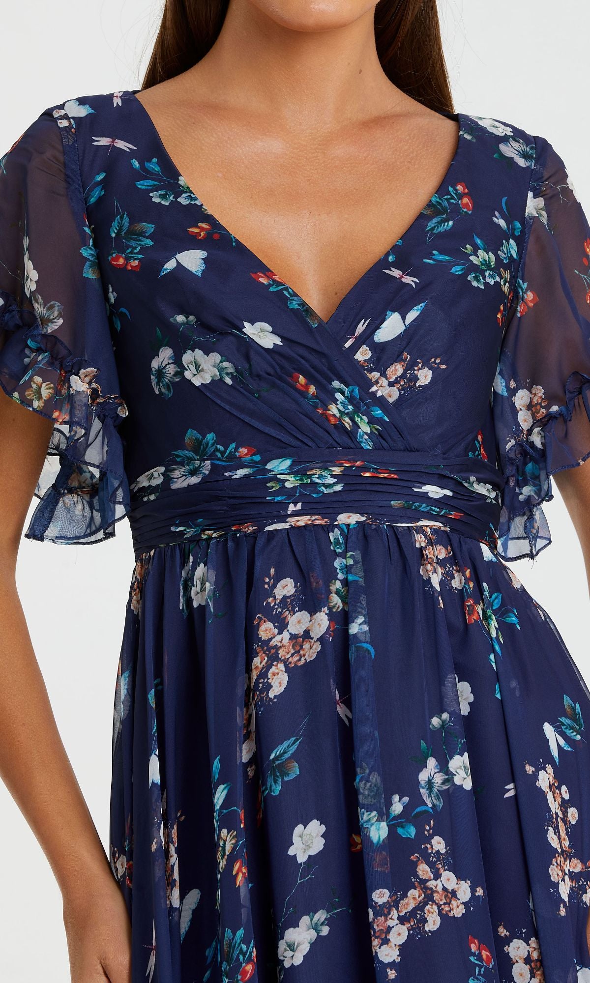A woman wearing the Floral-Print Long Formal Dress 70241 by Mac Duggal—a navy blue, Bohemian-style gown with a floral pattern, short ruffled sleeves, and a V-neckline.